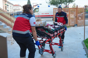 Burhaniye Belediyesi evde bakım hizmeti kapsamında yaşlı bir vatandaşa sağlık ekiplerinin evde müdahale ettiği an